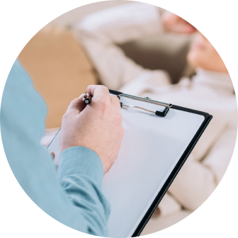 ADHD_sutrikimas_7 Healthcare professional writing on a clipboard during a patient consultation in a clinic or home setting.